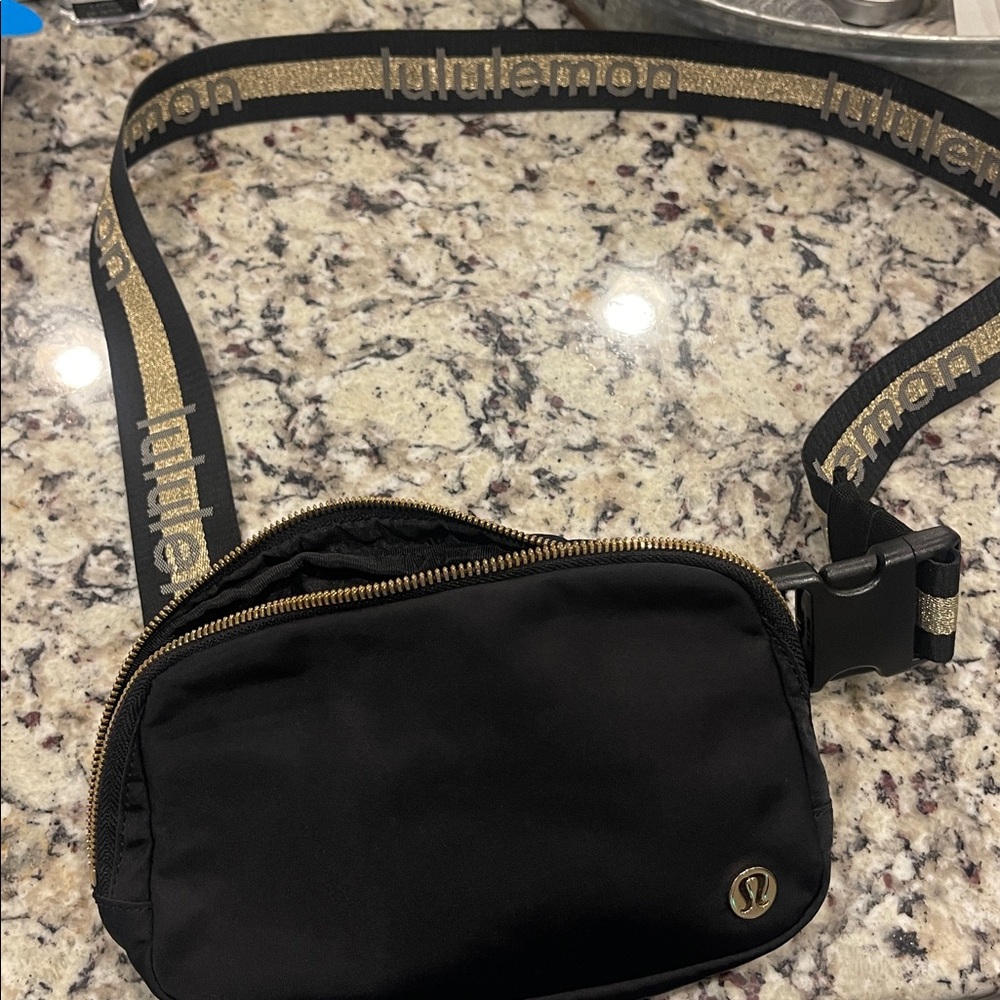 Lululemon Black belt Bag with Gold Zipper and long strap.